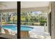 Screened-in pool with outdoor seating overlooks a serene backyard with mature trees and landscaping at 7300 Wax Myrtle Way, Sarasota, FL 34241