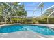 A luxurious screened in pool overlooking a lush backyard with scenic pond views at 7300 Wax Myrtle Way, Sarasota, FL 34241