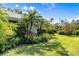 Lush yard featuring verdant landscaping and palm trees around the home at 7300 Wax Myrtle Way, Sarasota, FL 34241
