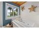 Bright bathroom features a jetted tub with a view of palm trees and a basket with soft towels at 7330 Westmoreland Dr, Sarasota, FL 34243