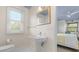 Bright bathroom showcasing a sleek pedestal sink and window with natural light at 7330 Westmoreland Dr, Sarasota, FL 34243