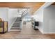 Spacious foyer with staircase, light walls, wood-look tile floors, and wood paneled ceilings at 7330 Westmoreland Dr, Sarasota, FL 34243