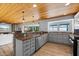 Modern kitchen with stainless steel appliances, granite countertops, wood-look tile floors, and views of the water at 7330 Westmoreland Dr, Sarasota, FL 34243