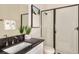 Modern bathroom featuring a dark countertop vanity with a framed mirror and glass door shower at 7561 Nighthawk Dr, Sarasota, FL 34241