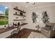 Bright home office featuring custom-built floating shelves, large window with outdoor views, and a cozy reading nook at 7561 Nighthawk Dr, Sarasota, FL 34241