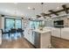 Open-concept kitchen with a marble island, stainless steel appliances, and exposed wood beams, with an adjacent dining and living area at 7561 Nighthawk Dr, Sarasota, FL 34241