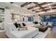 Spacious living room with a large white sectional, wooden coffee table, and an open view to the kitchen and dining area at 7561 Nighthawk Dr, Sarasota, FL 34241