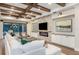Inviting living room featuring a brick fireplace, built-in wine rack, and exposed wood beams, with views to the outdoor space at 7561 Nighthawk Dr, Sarasota, FL 34241