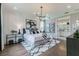 Well-lit main bedroom with modern chandelier, decorative wall art, and ensuite bathroom, creating a serene retreat at 7561 Nighthawk Dr, Sarasota, FL 34241