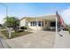 Charming single-story home featuring a covered parking area and well-maintained landscaping, enhanced by an American flag at 759 Lakeside Dr, North Port, FL 34287