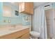 Bathroom with vanity, commode, and shower behind a curtain; bright walls at 772 Imperial Dr, North Port, FL 34287