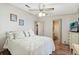 Comfortable bedroom with wood-look flooring, ceiling fan, and ensuite bathroom access at 772 Imperial Dr, North Port, FL 34287