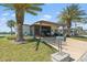 Charming single-story home with well-maintained lawn, palm trees, a carport, and cozy outdoor seating area at 772 Imperial Dr, North Port, FL 34287