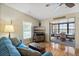 Relaxing living room featuring hardwood floors, cozy blue sofa, and seamless transition to sunroom at 772 Imperial Dr, North Port, FL 34287