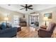 Comfortable living room featuring hardwood floors, cozy seating, and seamless transition to sunroom at 772 Imperial Dr, North Port, FL 34287