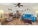Inviting living room with hardwood floors, comfortable seating, ceiling fan, and view into dining area at 772 Imperial Dr, North Port, FL 34287