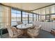 Relaxing sunroom with expansive lake views, wicker furniture, and a cozy dining setup at 772 Imperial Dr, North Port, FL 34287