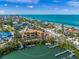 Aerial view of new waterfront construction with private dock, nestled amongst mature trees and waterfront views at 821 S Bay Blvd, Anna Maria, FL 34216