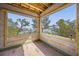 View of unfinished sun room showcasing a view of the bay framed by trees under a blue sky at 821 S Bay Blvd, Anna Maria, FL 34216