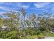 Scenic waterfront view with lush greenery and dock, framed by trees at 821 S Bay Blvd, Anna Maria, FL 34216