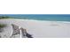 Picturesque beach view with a charming wooden bench offering a tranquil spot to enjoy the ocean breeze at 8625 Midnight Pass Rd # 305B, Siesta Key, FL 34242