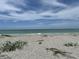 A pristine sandy beach and calm turquoise waters provides a relaxing waterfront experience, perfect for swimming and sunbathing at 8625 Midnight Pass Rd # 305B, Sarasota, FL 34242