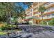 Condominium exterior featuring a covered entryway and lush landscaping at 8625 Midnight Pass Rd # 305B, Siesta Key, FL 34242