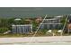 Aerial view of beachfront condos with lush greenery, tennis courts, and a beautiful sandy beach along the coast at 8625 Midnight Pass Rd # 305B, Siesta Key, FL 34242