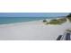 Wide sandy beach with turquoise water and lush vegetation, a tranquil coastal scene at 8625 Midnight Pass Rd # 305B, Siesta Key, FL 34242