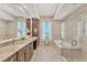 Bright bathroom with a soaking tub, separate shower and a large vanity with granite counters and double sinks at 10520 Boardwalk Loop # 503, Bradenton, FL 34202