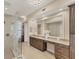 A bright bathroom features granite counters, double sinks, a separate vanity area, and a glass-enclosed shower at 10520 Boardwalk Loop # 503, Bradenton, FL 34202