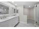 Bright bathroom featuring double sinks, white cabinetry, large mirrors, and a stand-up shower at 1211 Gulf Of Mexico Dr # 601, Longboat Key, FL 34228