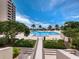 Beautiful pool area with swaying palms, inviting lounge chairs, and stunning ocean views at 1211 Gulf Of Mexico Dr # 601, Longboat Key, FL 34228