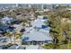 An aerial view focuses on the condo community with mature palms, green lawns, and well-maintained roofs at 1239 Siesta Bayside Dr # 1239C, Sarasota, FL 34242