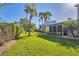 Lush green lawn with mature palm trees, offering a serene view of the neighborhood homes and greenery at 1239 Siesta Bayside Dr # 1239C, Sarasota, FL 34242