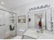 Bathroom featuring a shower with a glass door, a single sink vanity, decorative lighting, and a large mirror at 1239 Siesta Bayside Dr # 1239C, Sarasota, FL 34242