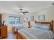 Bedroom featuring two beds with striped bedding, a ceiling fan, wood furniture, and beach-themed art at 1239 Siesta Bayside Dr # 1239C, Sarasota, FL 34242