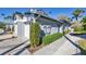 A side view shows mature landscaping, a white fence, and an easy access side entrance at 1239 Siesta Bayside Dr # 1239C, Sarasota, FL 34242