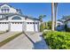 Well-manicured condo showing a three-car garage, tropical foliage, and lovely light-blue architectural trim at 1239 Siesta Bayside Dr # 1239C, Sarasota, FL 34242