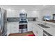 Bright kitchen features stainless steel appliances, white cabinets, grey backsplash and breakfast bar at 1239 Siesta Bayside Dr # 1239C, Sarasota, FL 34242
