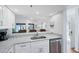 Modern kitchen with stainless steel appliances, granite countertops, and a breakfast bar that opens to living room at 1239 Siesta Bayside Dr # 1239C, Sarasota, FL 34242