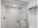 Modern walk-in shower featuring marble-style tile, a glass door, sleek fixtures, and pebble flooring at 1239 Siesta Bayside Dr # 1239C, Sarasota, FL 34242