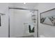 Shower featuring gray tile, glass door, sleek fixtures, shower caddy, and a beach-themed decoration at 1239 Siesta Bayside Dr # 1239C, Sarasota, FL 34242