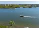 Scenic water view featuring a boat cruising near lush mangroves and waterfront homes, perfect for relaxed coastal living at 1239 Siesta Bayside Dr # 1239C, Sarasota, FL 34242