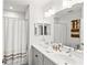 Bright bathroom featuring a double sink vanity, large mirror, and shower with curtain at 12959 Seasong Ter, Bradenton, FL 34211