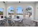 Outdoor community space with tables, chairs, and a view of the pool area with palm trees and other landscaping at 12959 Seasong Ter, Bradenton, FL 34211