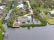 Waterfront home featuring a pool, tiki hut, dock, and tropical landscaping at 1410 San Jose Dr, Englewood, FL 34223