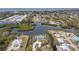 Aerial view of the waterfront home featuring a pool, boat dock, and lush greenery at 1410 San Jose Dr, Englewood, FL 34223