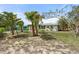 Lovely single-story home with lush landscaping, a pergola, and a partial driveway view at 1410 San Jose Dr, Englewood, FL 34223