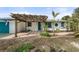 Welcoming home exterior featuring a pergola over the walkway, a green door, and tropical landscaping at 1410 San Jose Dr, Englewood, FL 34223